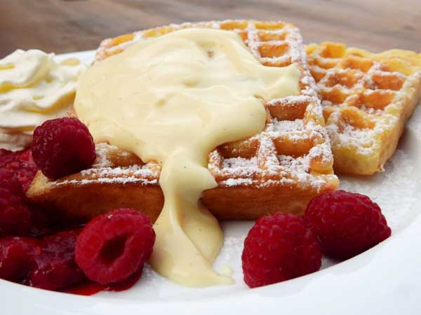 crema pastelera sobre gofres con frambuesas